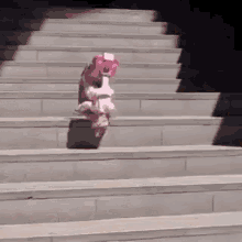 a little girl in a pink dress is riding a pink scooter down a set of stairs .