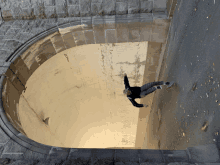 a person is doing a trick on a skateboard in a tunnel with a brick wall