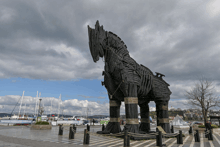 a statue of a horse is in front of a marina with boats docked