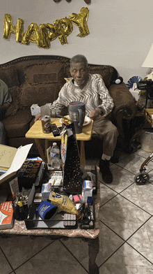 an elderly man sits in a living room with a happy balloon behind him