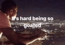 a man is sitting on a ledge with the words it 's hard being so goated
