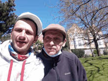 a man wearing a columbia jacket stands next to an older man