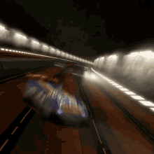 a blurred image of a car driving through a tunnel at night