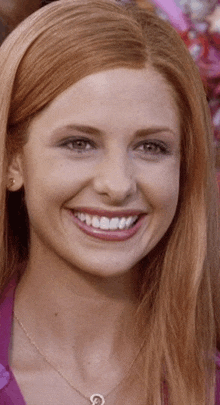 a close up of a woman 's face with a necklace and earrings