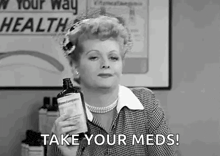 a woman is holding a bottle of medicine and says `` take your meds ! ''
