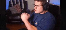 a man wearing glasses and headphones is sitting in a chair in a living room .