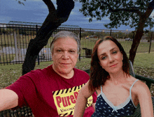 a man and a woman are posing for a picture and the man is wearing a pure vaccinated shirt