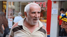 a man with a beard stands in front of a store that has the word ste on it