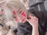 a girl with red paint on her face has the number 070 on her sleeve