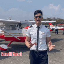 a man in a pilot 's uniform stands in front of a plane with the words " enroll now " written below him