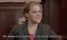 a woman in a suit is saying we deserve to dance like no one 's watching ...