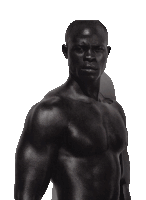 a man without a shirt is standing in the dark