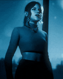 a woman wearing a blue turtleneck sweater and a black skirt