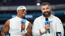 two football players are talking into microphones and one has a beard