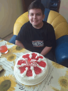 a boy wearing a shirt that says merci is sitting at a table