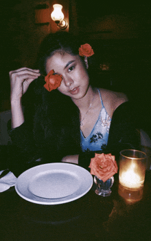 a woman with roses in her hair is sitting at a table