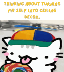 a drawing of a cat wearing a colorful hat with the words thinking about turning my self into ceiling decor