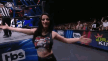 a woman is standing in a wrestling ring with her arms outstretched in front of a tbs ad