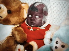 a baby with a purple face is surrounded by stuffed animals including a teddy bear