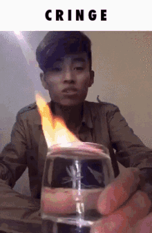 a man is holding a glass with a flame coming out of it and the word cringe above him