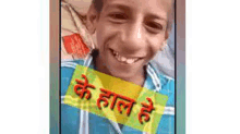 a young boy is smiling for the camera on a cell phone with a yellow sticker on it .