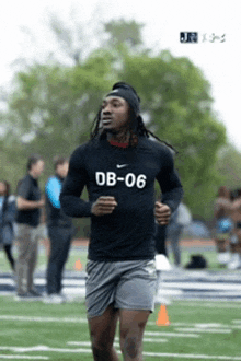 a man running on a field wearing a shirt that says db- 06