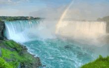 a waterfall with a double rainbow in the background