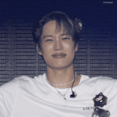 a close up of a person wearing a white shirt that says ixion