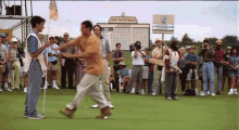 a group of people on a golf course with a sign that says at & t national in the background