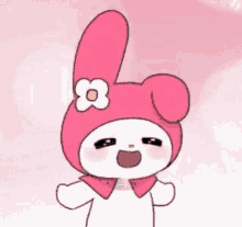 a pink bunny with a flower on its head is smiling .