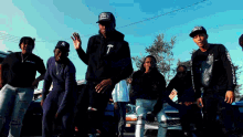 a group of young men are standing in a parking lot and one of them has a ny hat on