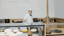 a man in a chef 's uniform stands behind a glass display case with a sign that says republic of booze