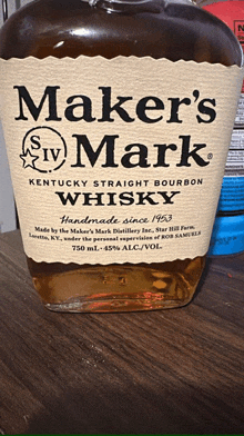 a bottle of maker 's mark kentucky straight bourbon whisky sits on a table