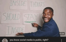 a man is writing on a whiteboard with a marker and smiling .