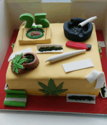 a cake with a marijuana leaf and the number 25 on top