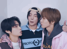 three young men are standing next to each other and one of them is wearing a shirt that says prototype