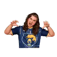 a man with long hair is wearing a blue and yellow shirt with a bear on it