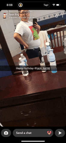 a man is taking a selfie in front of a mirror with a message that says happy birthday