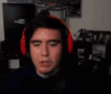 a man wearing headphones is singing into a microphone in a dark room .