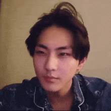 a close up of a young man 's face wearing a pajama shirt .