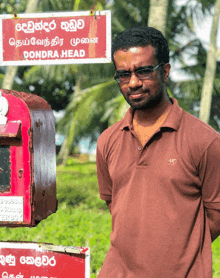 a man in a brown shirt stands in front of a sign that says dondra head