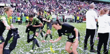 a group of female soccer players are celebrating on the field and one of their shirts has the number 23 on the back