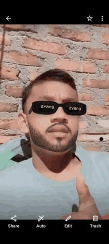 a man with a beard wears sunglasses that say ayang