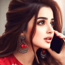 a woman wearing red earrings is talking on her cell phone