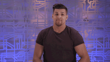 a man in a black shirt is standing in front of a purple background with the letter n visible