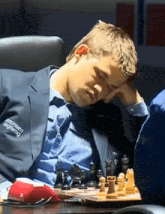 a man playing chess with a jacket that says " aaronsen "