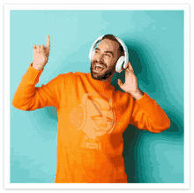 a man wearing headphones and an orange sweater with a robot on it