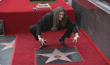 a man kneeling down in front of a star that says weird al vankovic