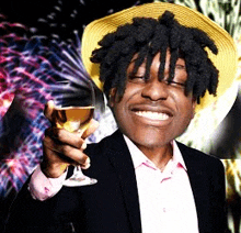 a man wearing a hat is holding a glass of wine and smiling