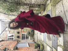 a woman in a red dress is standing in front of a brick building with a sign that says ' no '